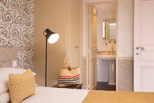 巴黎Hotel Relais Bosquet by Malone的一间卧室配有一张床,浴室设有水槽
