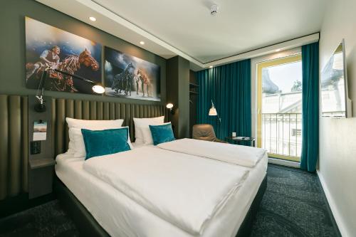 柏林柏林库杜姆1号汽车酒店的卧室配有带蓝色枕头的大型白色床