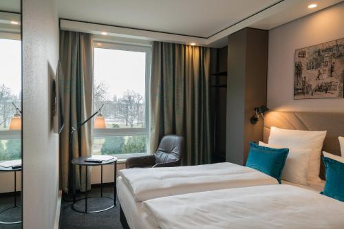 德累斯顿德芮思登-帕拉斯广场1号汽车酒店的酒店客房设有两张床和窗户。