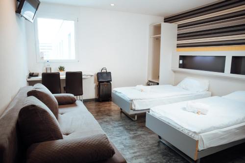 吉维西伊兹My Hotel Fribourg的酒店客房,设有两张床和一张沙发