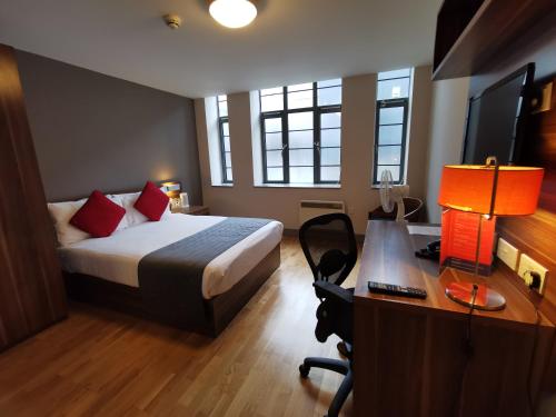 布莱顿霍夫不列颠思达戴酒店的酒店客房配有一张床、一张书桌和一张书桌。