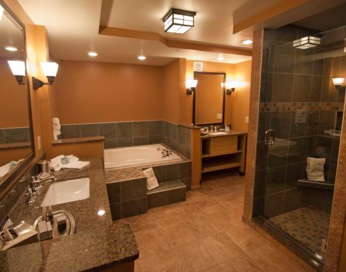 克莱顿1000群岛港口酒店的大型浴室设有浴缸和淋浴。