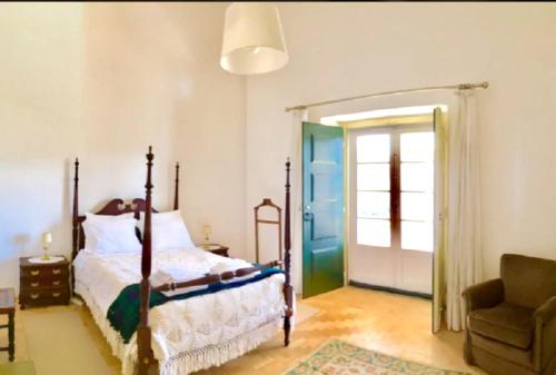 Praia do Ribatejo2 bedrooms appartement at Praia do Ribatejo 200 m away from the beach with lake view enclosed garden and wifi的卧室配有床、椅子和门