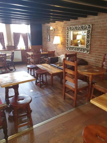 贝弗利Windmill Bed and Breakfast的餐厅设有木桌、椅子和镜子