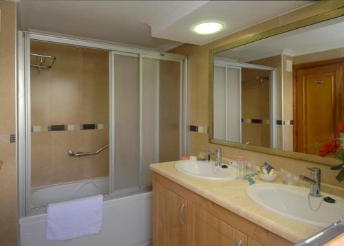洛斯克里斯蒂亚诺斯Beverly Hills Suites - Excel Hotels & Resorts的带淋浴、盥洗盆和镜子的浴室