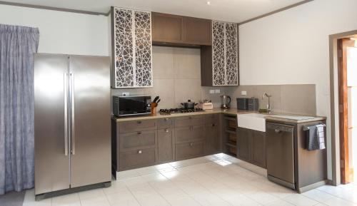 WaipapaGuinea's Rest的厨房配有棕色橱柜和不锈钢冰箱