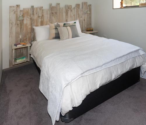 WaipapaGuinea's Rest的卧室配有带枕头的大型白色床