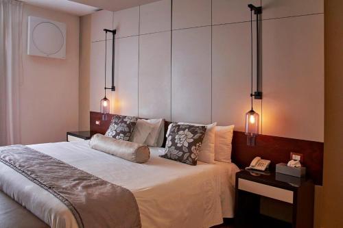 阿瓜斯卡连特斯Alesia - Boutique Hotel & Spa的一间卧室配有一张大床和两盏灯