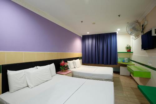 米里Cosy Inn的一间卧室配有两张床和蓝色窗帘