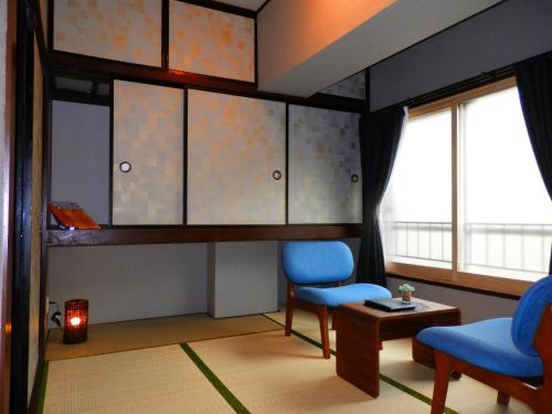 札幌Maple Sumikawa #202的客厅配有2把蓝色椅子和桌子