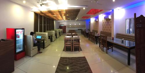 瑞诗凯诗Hotel Trihari的一间带桌椅和视频游戏的餐厅