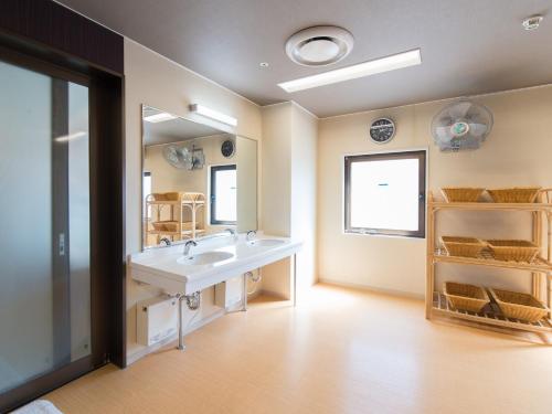 北九州Tabist Hotel Tetora Kitakyushu的一间带水槽和大镜子的浴室