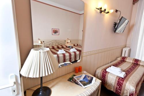 那不勒斯那不勒斯市中心住宿加早餐酒店的一间卧室配有两张床、一盏灯和镜子
