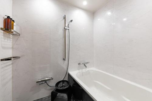 福冈The OneFive Terrace Fukuoka的白色的浴室设有浴缸和卫生间。