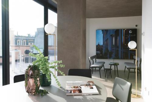 米兰Milan Eleven by Brera Apartments的一间带桌椅和大窗户的用餐室