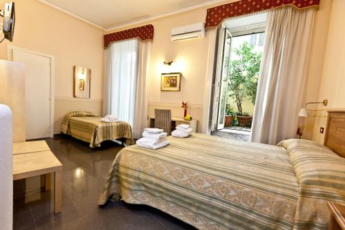 那不勒斯那不勒斯市中心住宿加早餐酒店的酒店客房设有两张床和窗户。