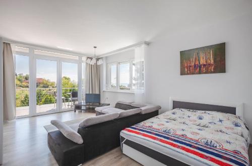 巴拉顿阿卡拉提亚Mirador Balaton design Villa的一间卧室配有一张床和一张沙发