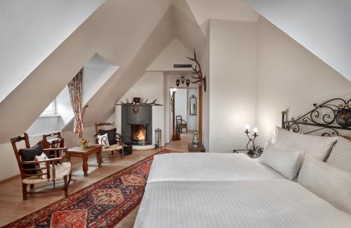 因斯布鲁克施沃泽阿德勒因斯布鲁克酒店的一间卧室配有一张床和一个壁炉