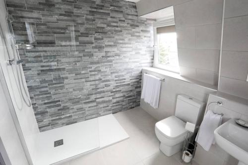 柯金蒂洛赫Broadcroft Hotel的浴室设有白色卫生间和砖墙
