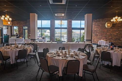 柯金蒂洛赫Broadcroft Hotel的宴会厅配有桌椅和白色的桌布