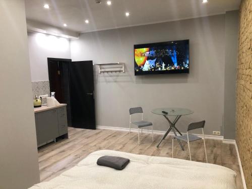 里加里加公寓式酒店的一间设有桌子和墙上电视的房间