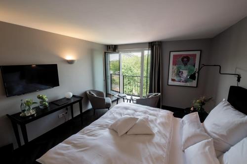 科隆Prevôt Restaurant & Hotel的卧室配有白色的床和电视。
