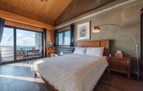 南海郡南海郡鲸鱼之梦的一间卧室设有一张大床和一个大窗户
