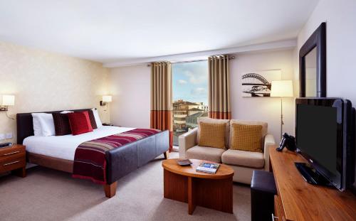 泰恩河畔纽卡斯尔纽卡斯尔驻桥套房假日酒店的配有一张床和一台平面电视的酒店客房