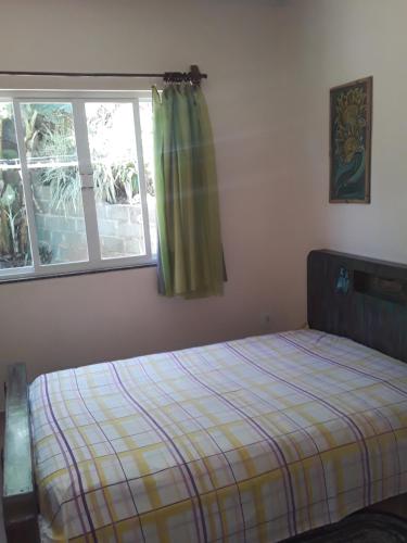 皮拉图巴Casa aconchegante em estilo rústico的一间卧室设有一张床和一个窗口
