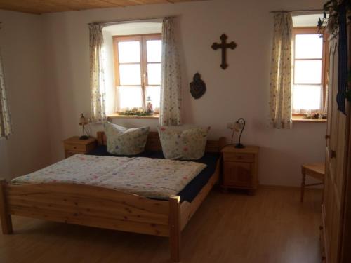 希明格Irgenbauer的一间卧室设有床、两个窗户和十字架