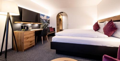 安德马特施鲁塞尔阿尔盆酒店的配有一张床和一张书桌的酒店客房