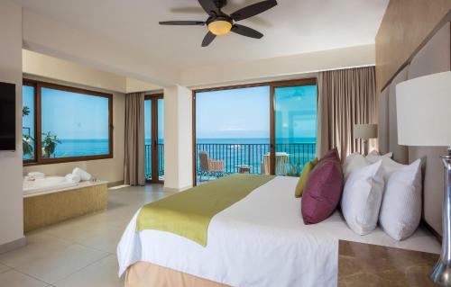 巴亚尔塔港阿尔玛豪华度假村 - LGBT海滩体验的一间卧室设有一张床,享有海景