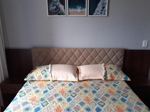 新弗里堡Loft super charmoso no centro de Nova Friburgo的一张带被子的床和两个枕头