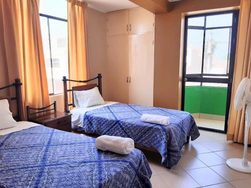 皮斯科Sol de Paracas Apart Hotel的一间卧室配有两张带毛巾的床