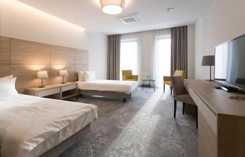 克罗斯诺Polanka Conference Center的配有一张床和一张书桌的酒店客房