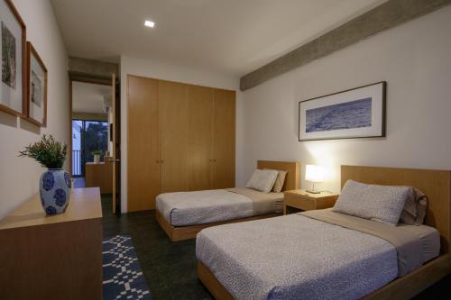 瓜达拉哈拉Apartamentos Buenos Aires的一间酒店客房,设有两张床和走廊