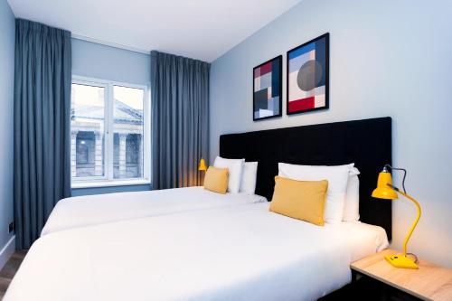 都柏林Staycity Aparthotels, Dublin, Christchurch的卧室设有一张白色大床和一扇窗户。