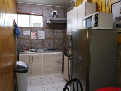 蒙特港Hostal Copiapó Puerto Montt的厨房配有不锈钢冰箱和水槽