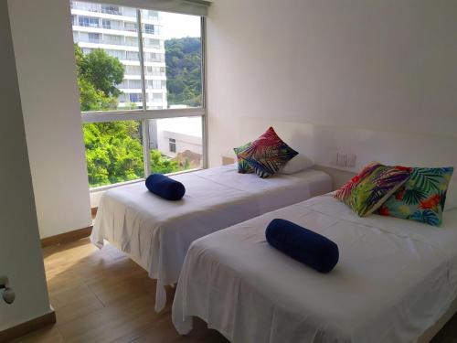 阿卡普尔科Departamento con Preciosa Vista al Mar en Acapulco Diamante的带大窗户的客房内的两张床