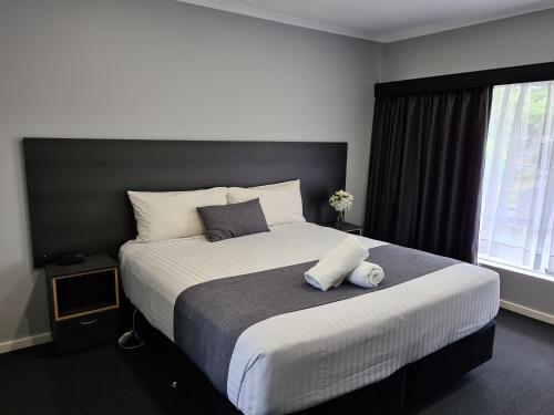 阿尔弗斯通海滩长廊汽车旅馆的一间卧室设有一张大床和一个窗户。