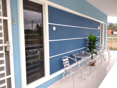 BalingSacha Homestay的一个带椅子和一张桌子的蓝色墙壁庭院