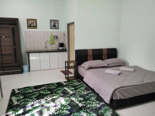 BalingSacha Homestay的一间卧室配有一张带绿毯的床