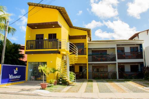 嘎林海斯港Pousada Velosmar的一座黄色的建筑,前面有楼梯