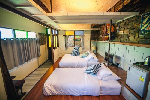 春武里Suankaew​ art​ hostel​的一间房间里三张床的组合