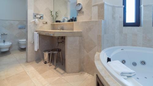 阿尔啼SH加迪亚别墅酒店的带浴缸、盥洗盆和卫生间的浴室