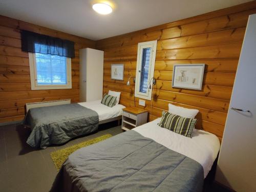 库奥皮奥劳哈拉赫蒂度假村的木墙客房的两张床