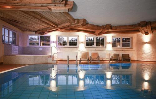 塞布鲁克瓦赛曼希酒店的大楼内带椅子的大型游泳池