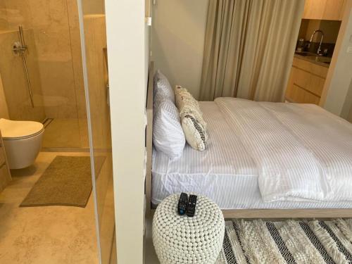 荷兹利亚daniel hotel beach view boutique apt的一间卧室配有一张床,浴室设有淋浴。