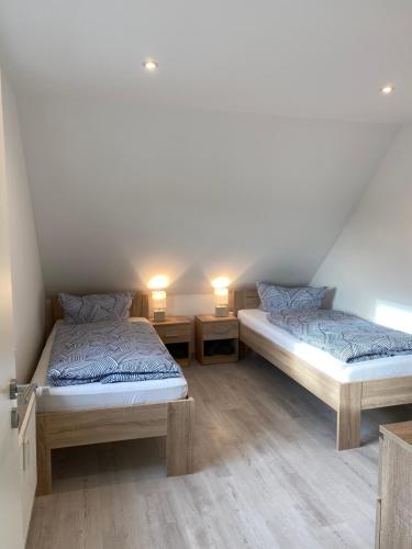 RoßlebenFerienwohnung Hendrich Roßleben的配有2张单人床的客房,配有2盏灯