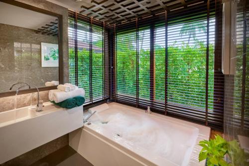 卡农Khanom Beach Resort And Spa的带浴缸的浴室和大窗户